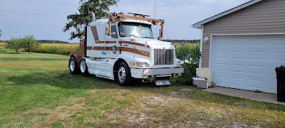 A semi truck is parked in front of a garage.