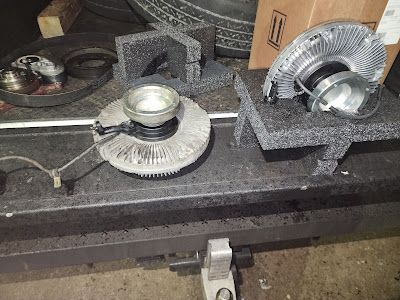 A fan is sitting on top of a table next to a tire.