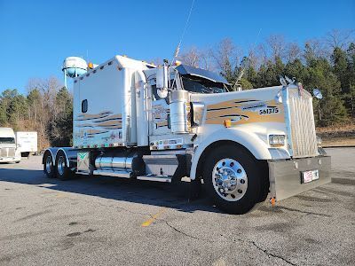 A white semi truck is parked in a parking lot.