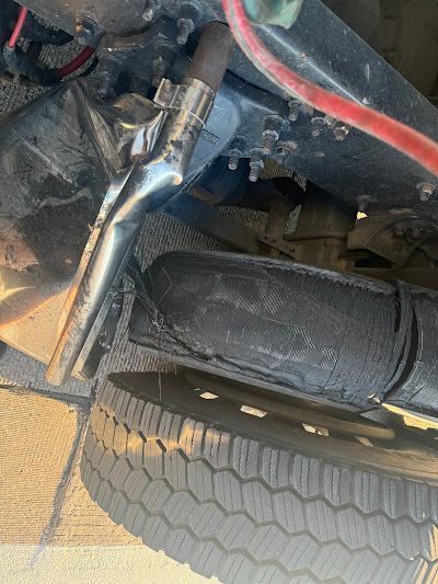 A close up of a tire and exhaust pipe on a car.