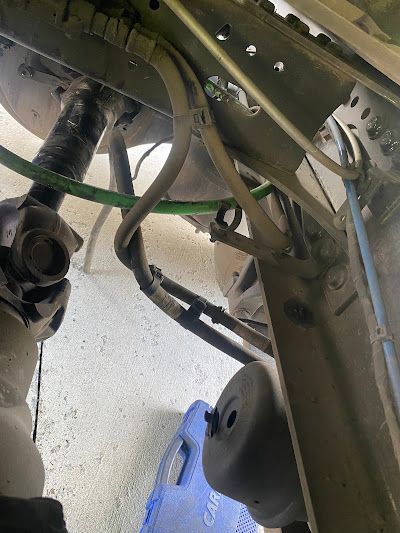 A close up of the underside of a car with a blue box in the background.