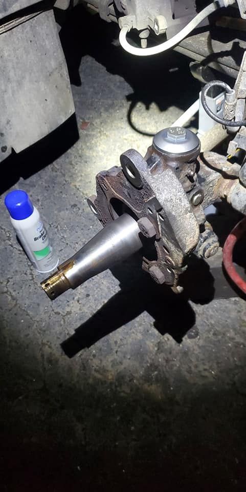 A piece of metal is sitting on the ground next to a spray bottle.