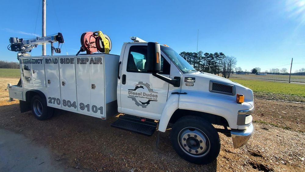 A white utility truck is parked on the side of the road.