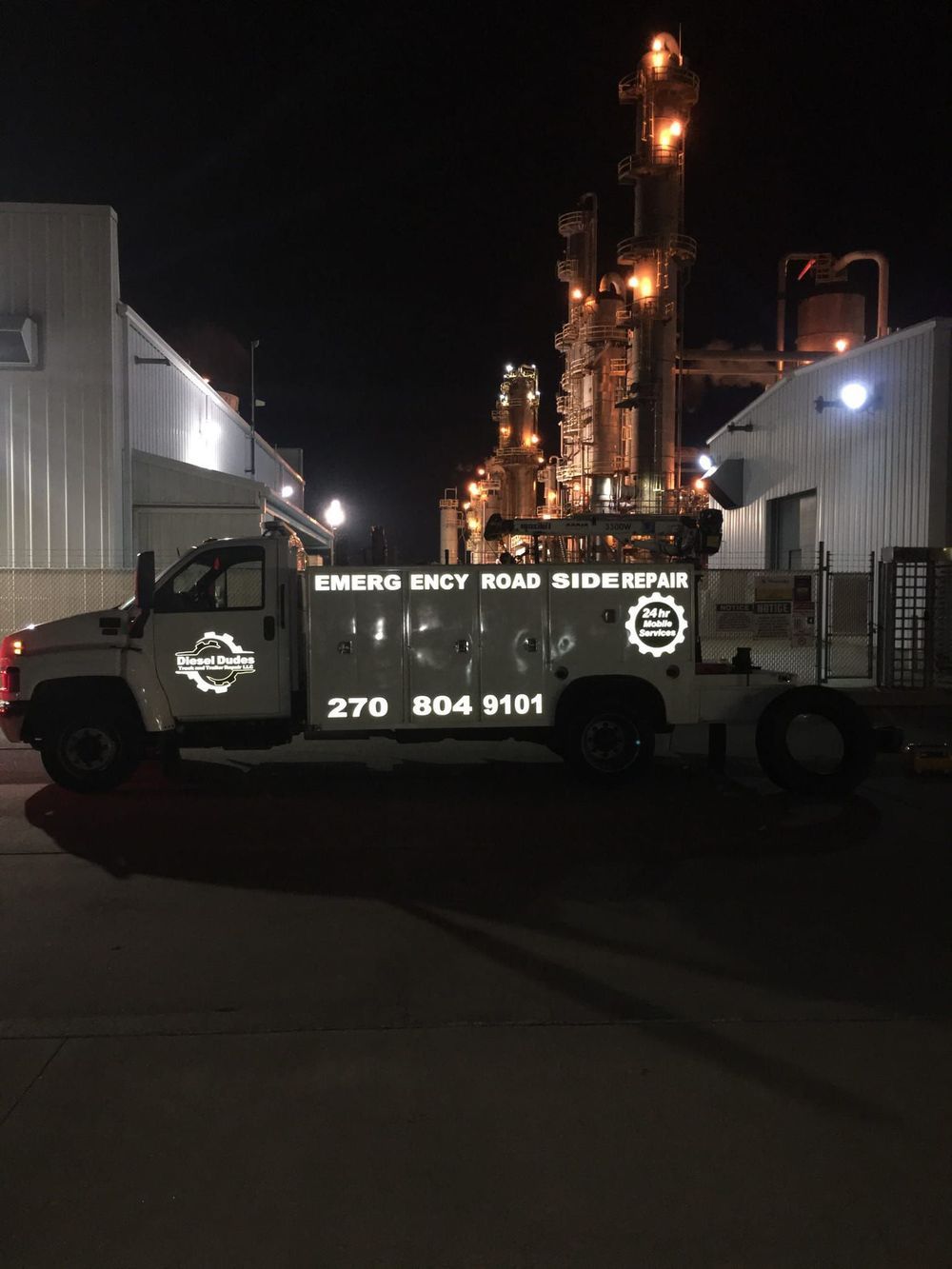 A truck is parked in front of a building at night.