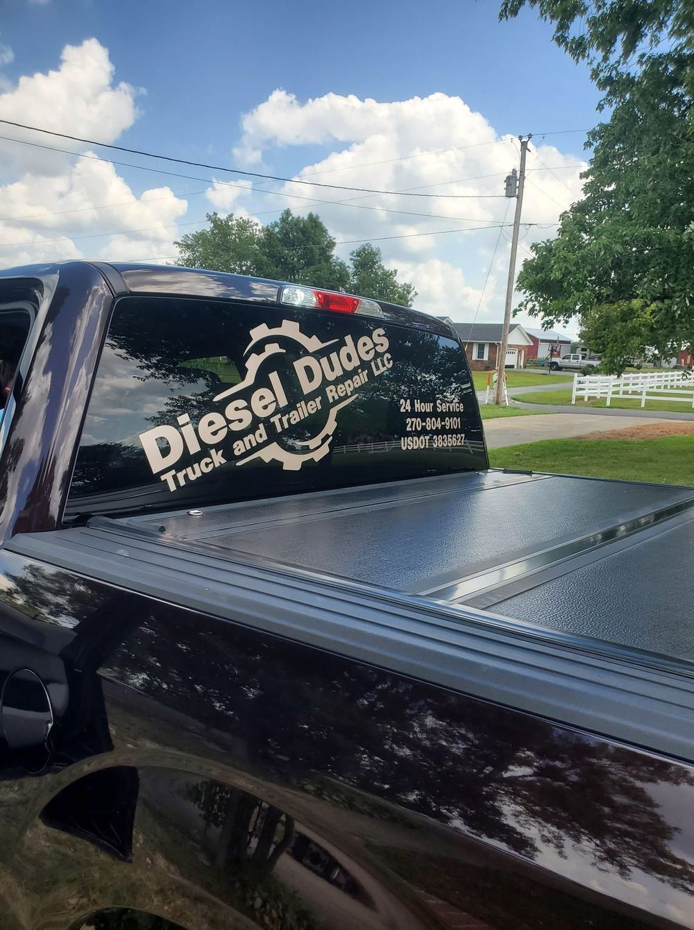 A black truck with a diesel dudes sticker on the back window.