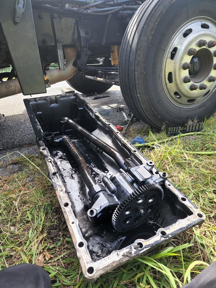 A truck is being repaired on the side of the road.