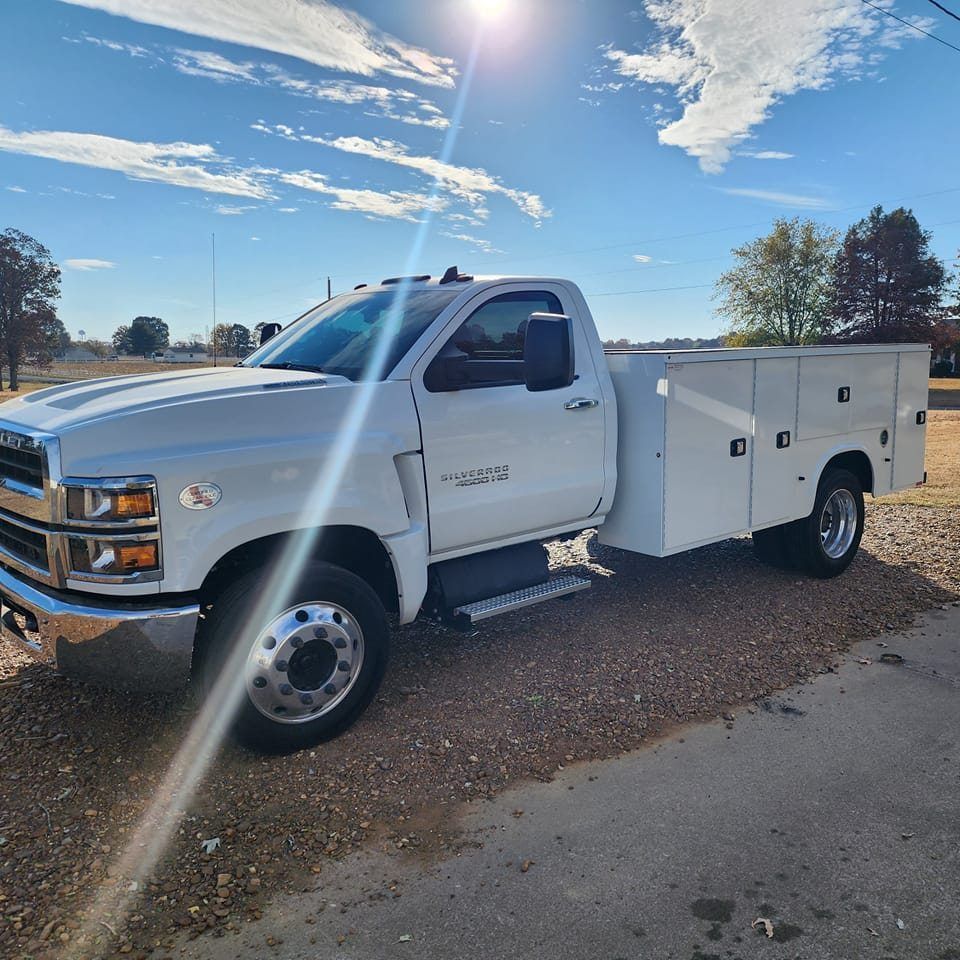 A white utility truck is parked on the side of the road