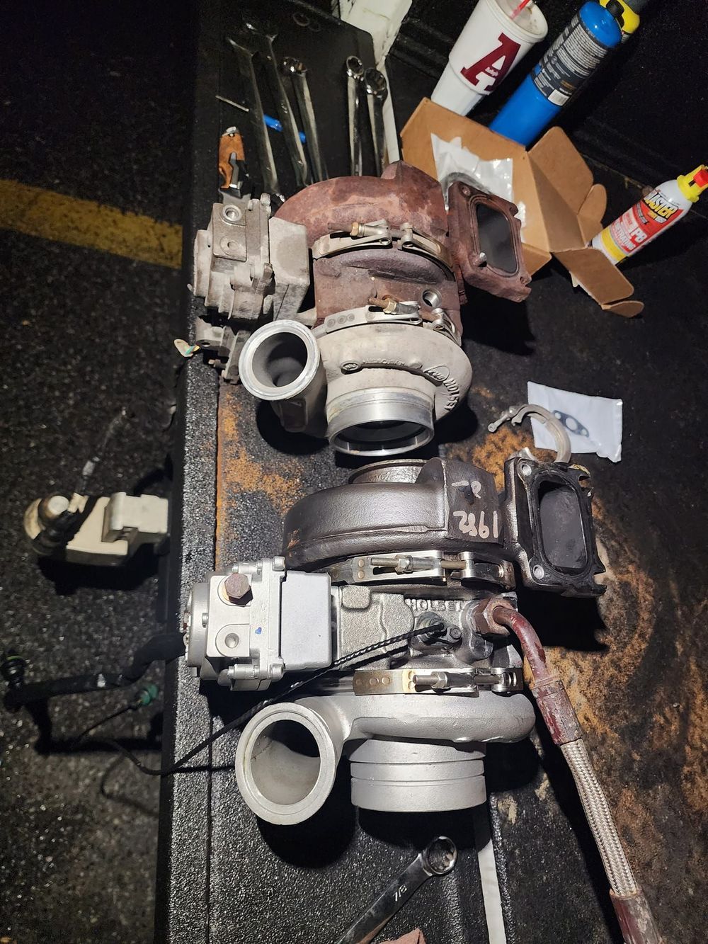 Two turbochargers are sitting on top of each other on a table.