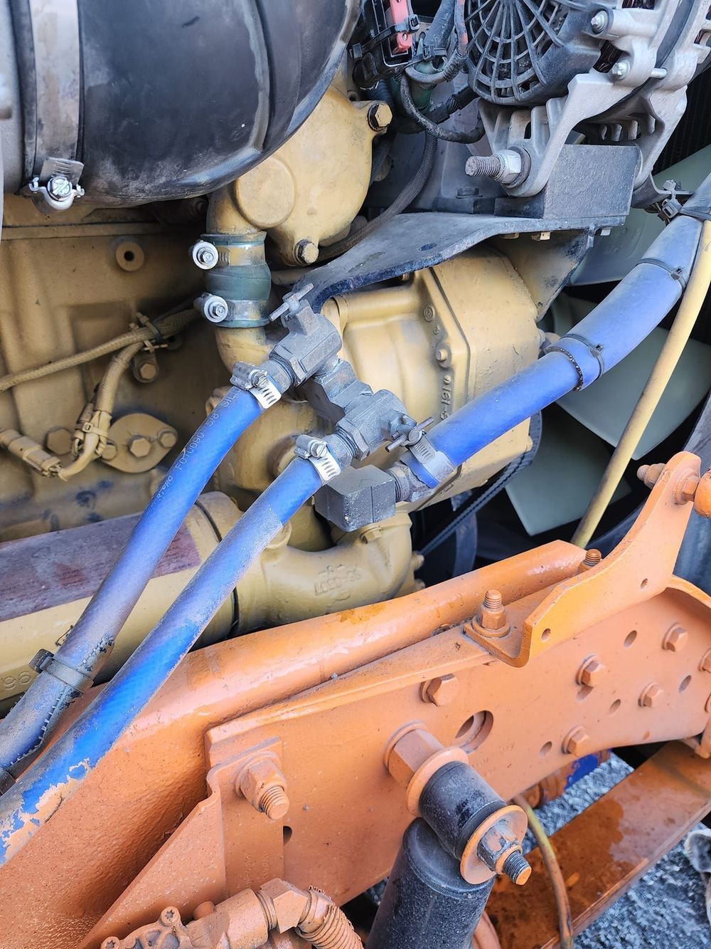 A close up of a truck engine with blue hoses attached to it.