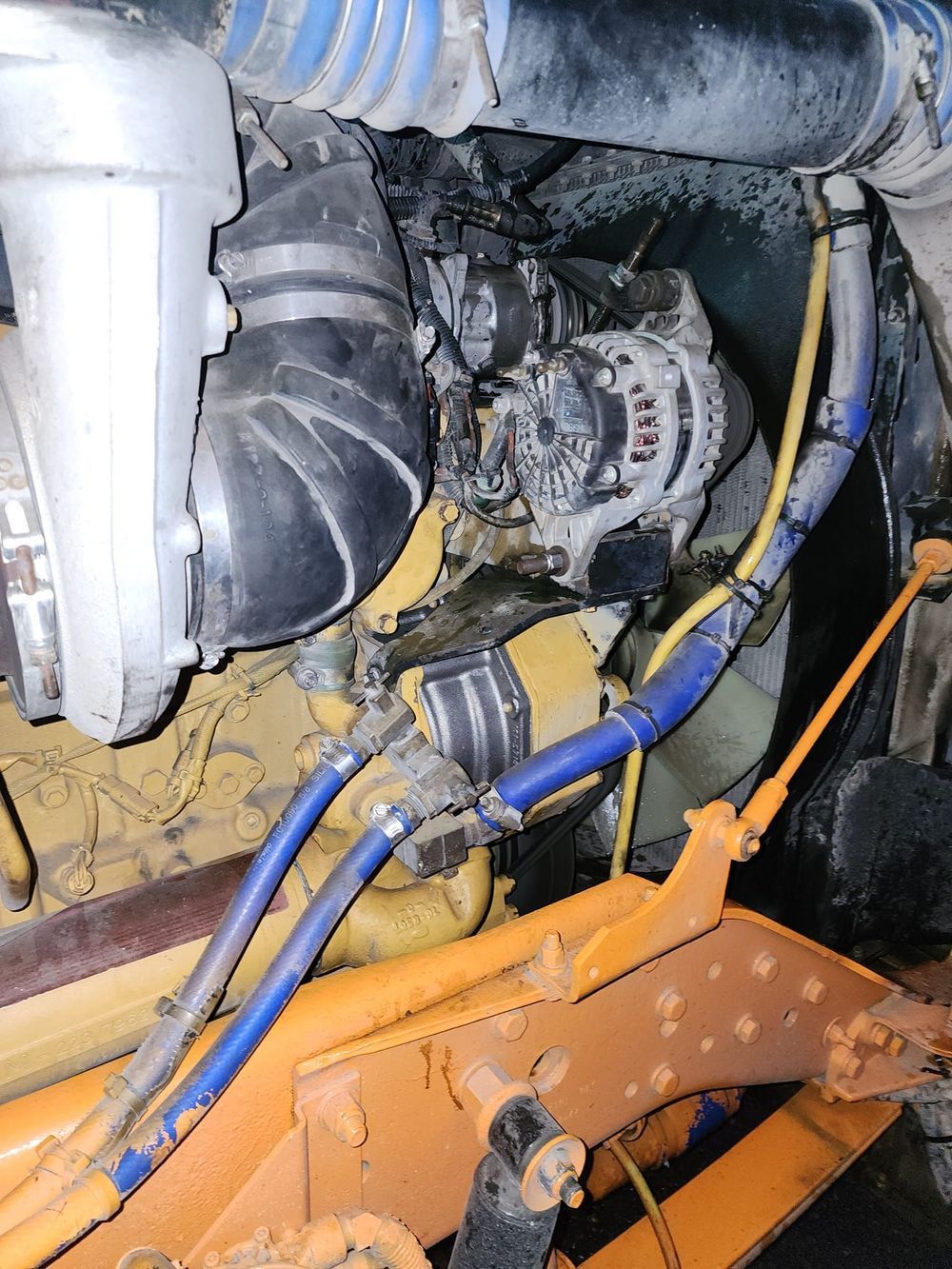 A close up of a diesel engine with a hose coming out of it