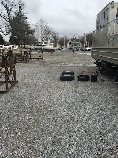 A rv is parked in a gravel lot with tires on the ground.