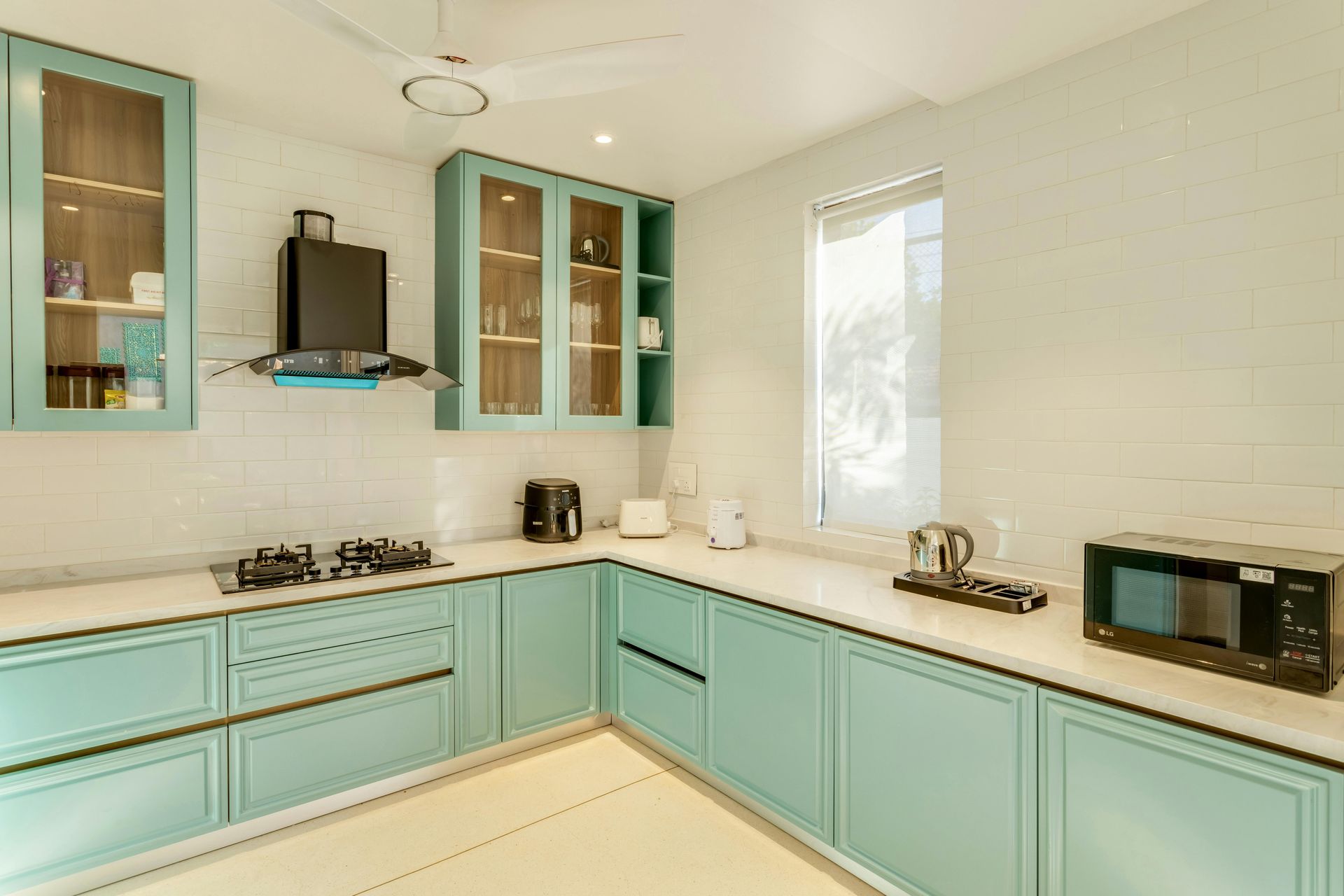 Light blue kitchen with white countertops, cabinets, and appliances.