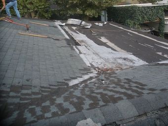 A man is working on a roof with a broom