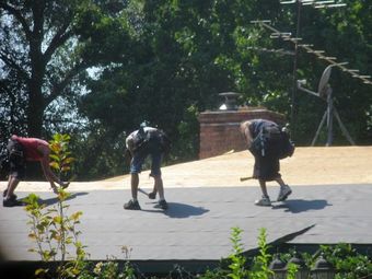 A row of roofs with trees and mountains in the background