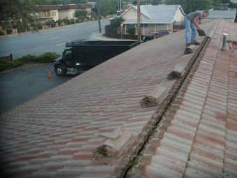 A man is working on the roof of a building