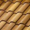 A close up of a row of brown tiles on a roof.