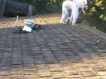 Two men are working on a wood roof