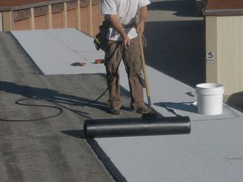 A man is working on a roof with a torch