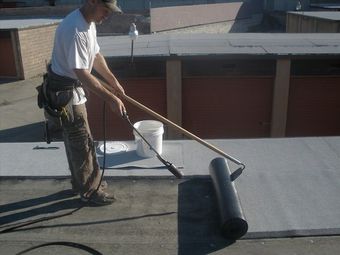 A man is working on a roof with a torch