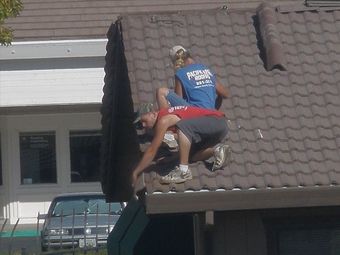 Men working on a tile roof