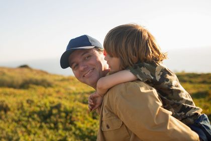 A man and a woman are standing next to each other in a park.
