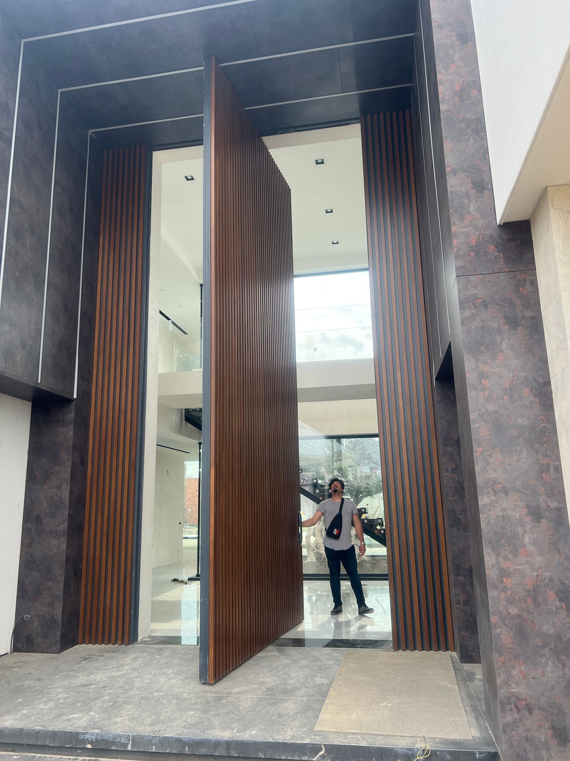 A man is standing in front of a large wooden door