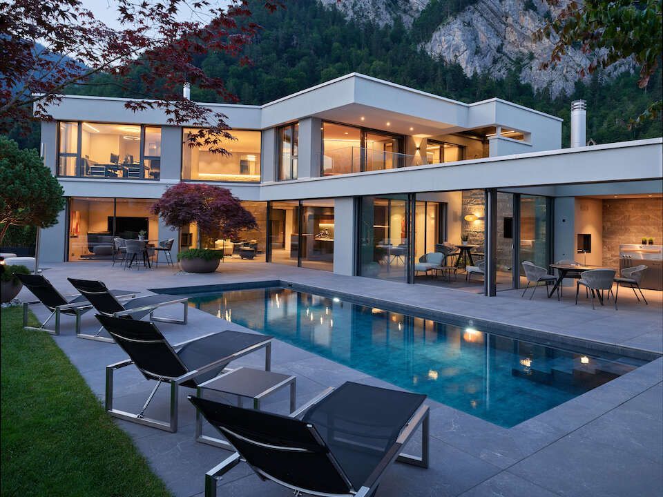 A large house with a large swimming pool in front of it