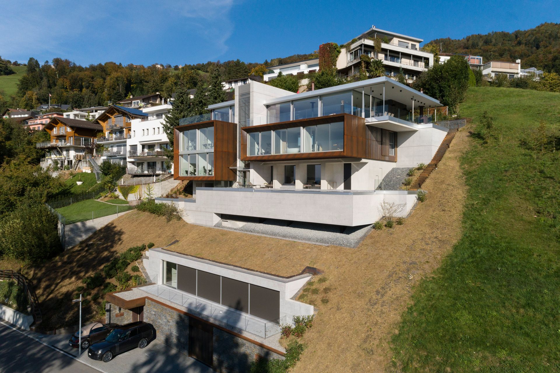 An aerial view of a large house sitting on top of a hill.