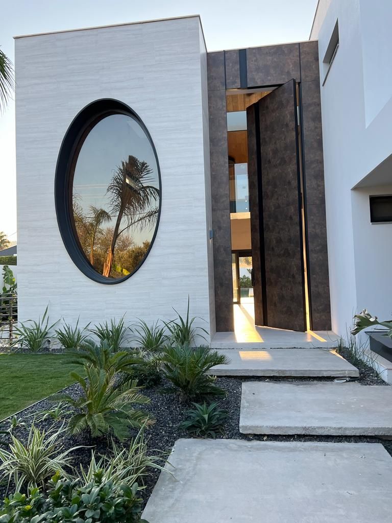 A modern house with a large round window on the side of it.