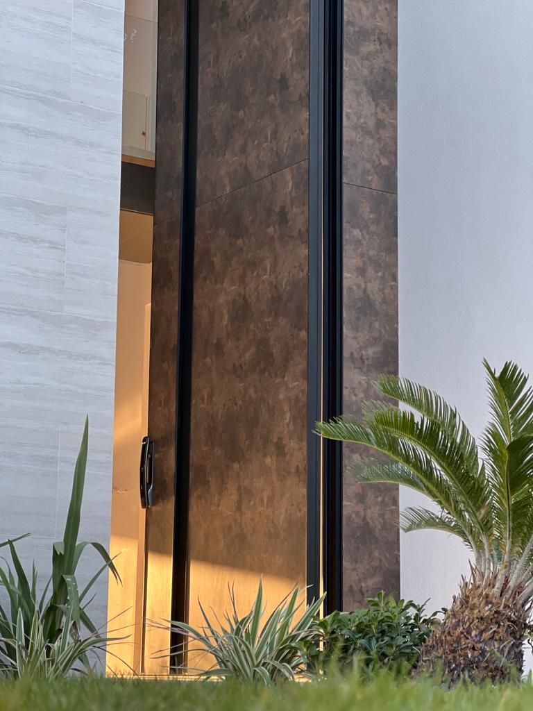 A close up of a door with a palm tree in front of it.