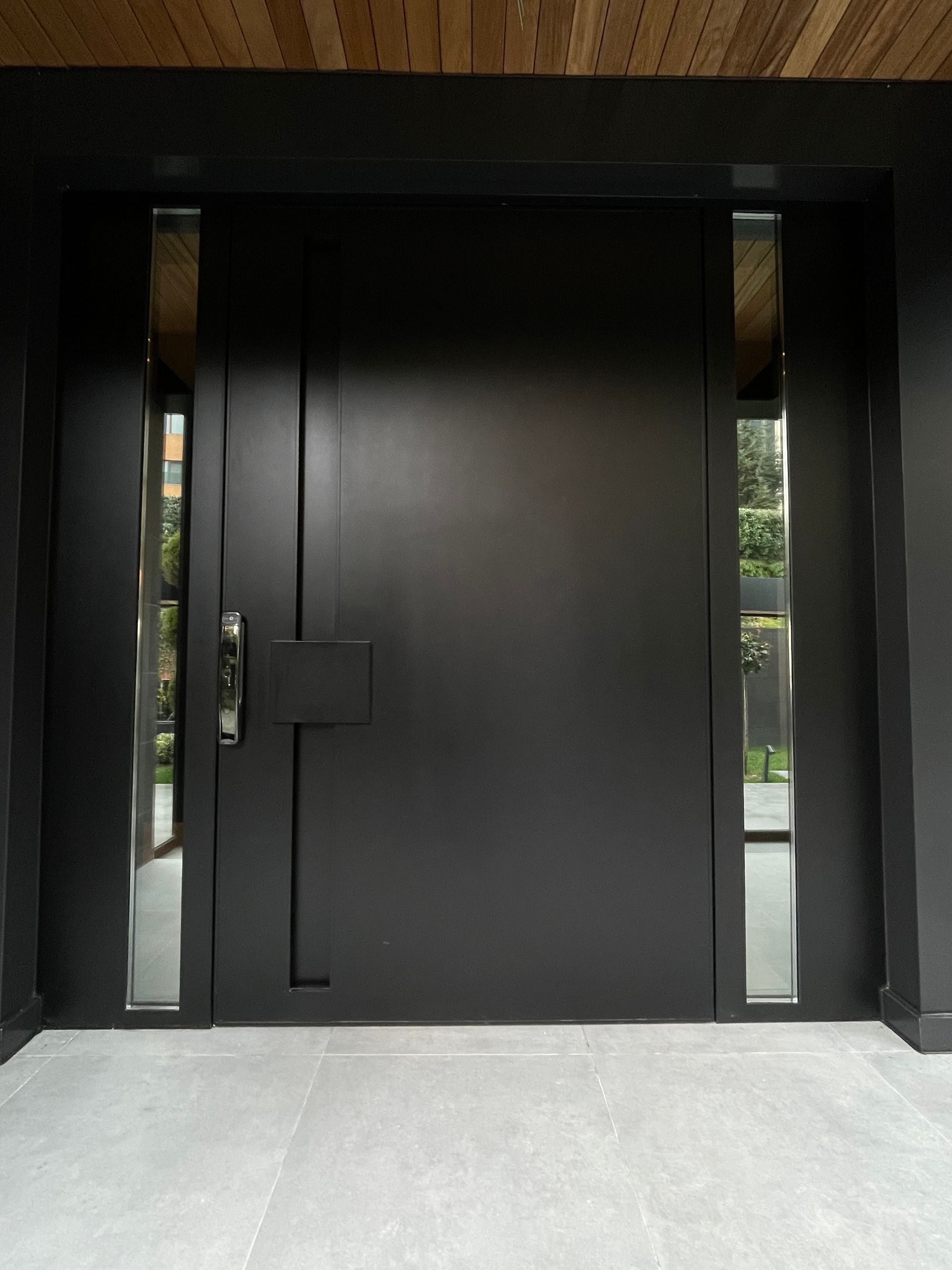 A large black door with a wooden ceiling