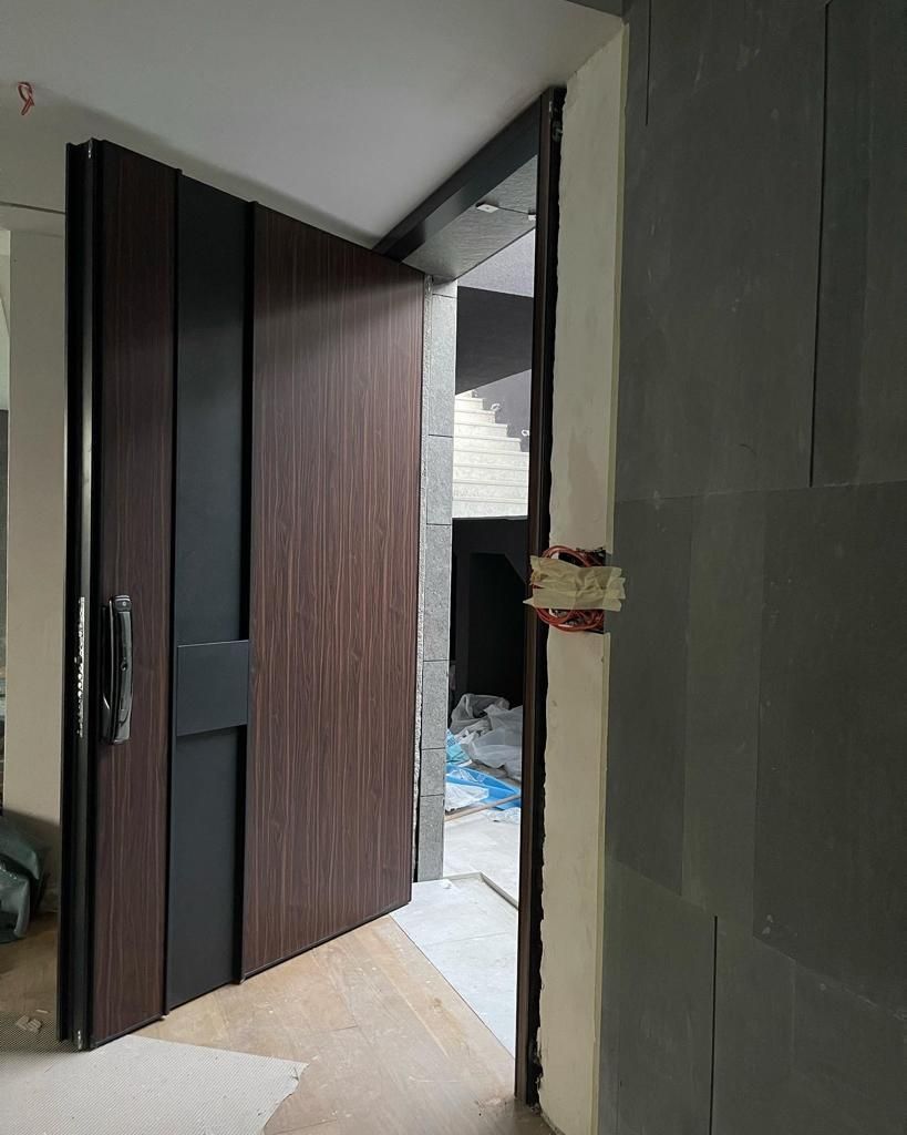 A large wooden door is open in a hallway.