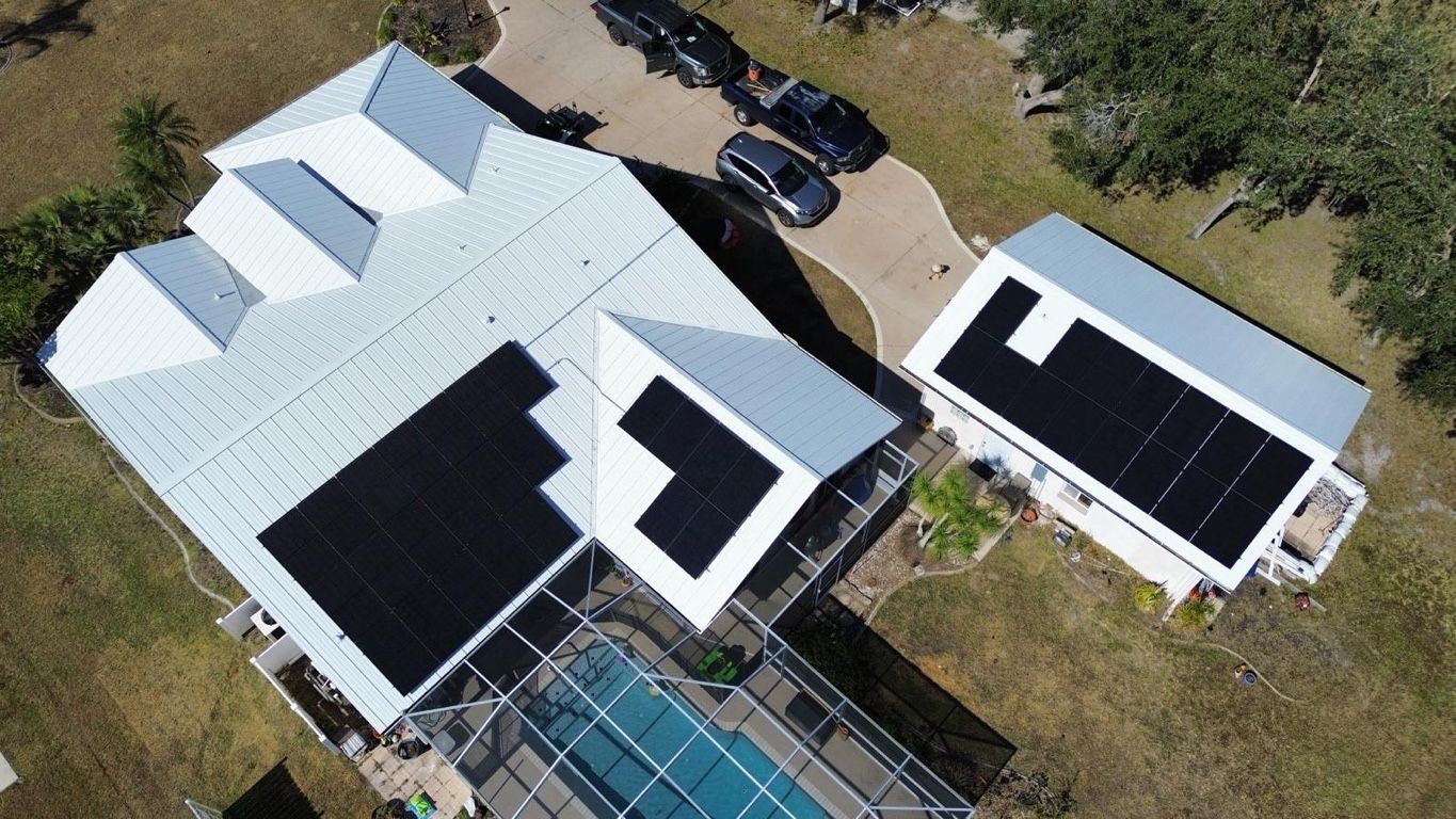 View of a corrugated metal roof with a white coating, a person, and blue sky with clouds.