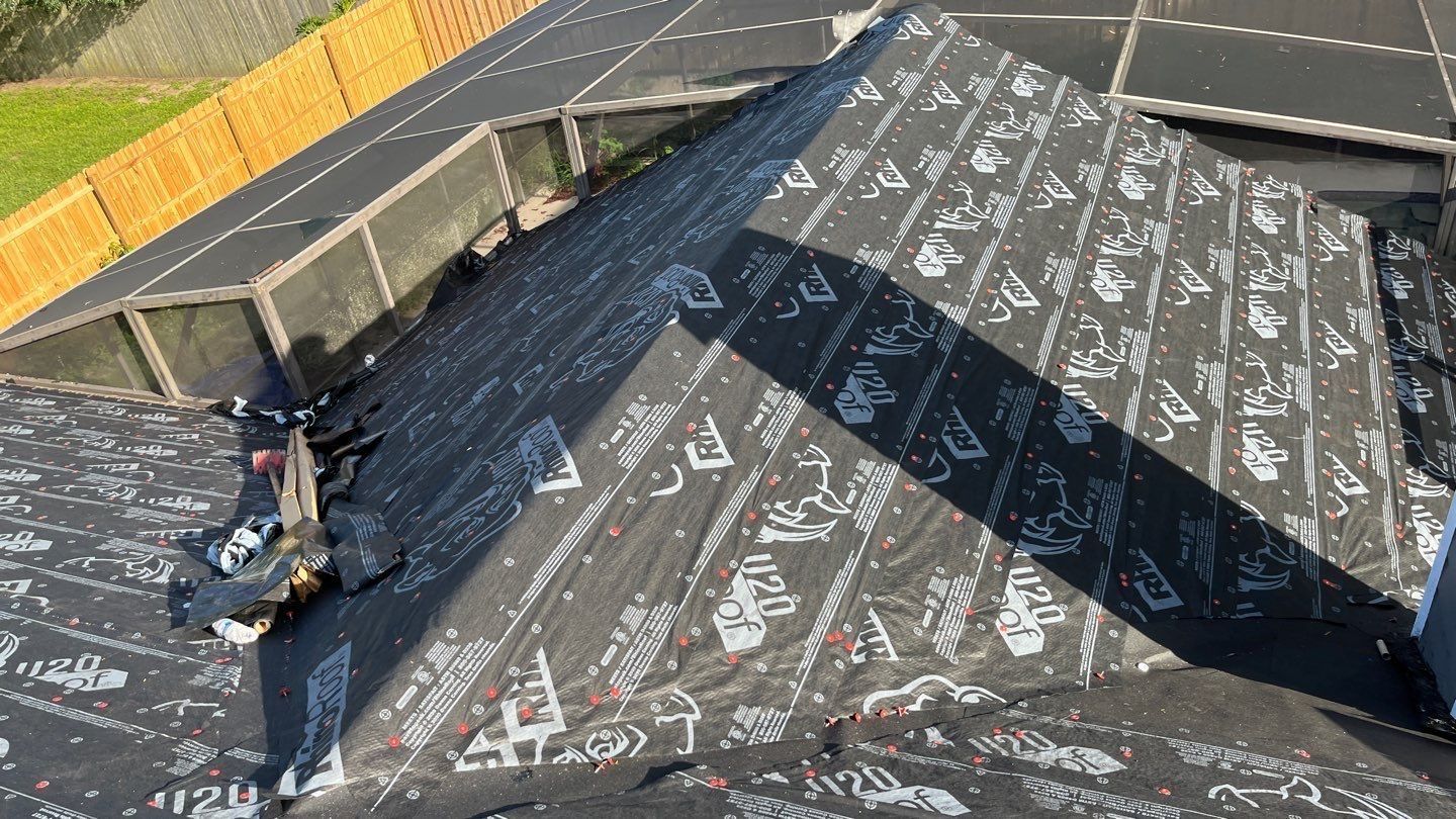 Roof being constructed; black roofing material with white patterns. A partially finished job.