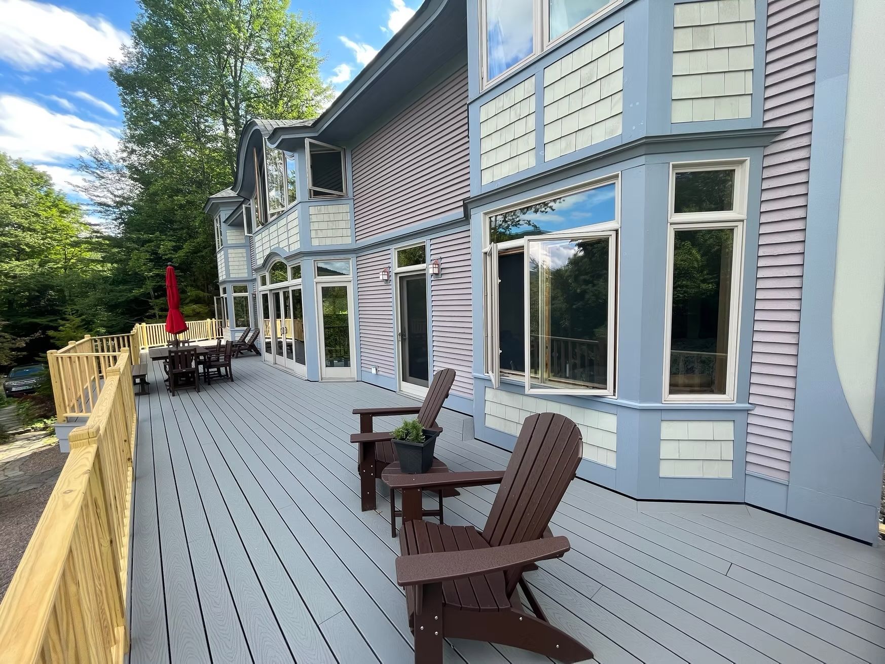 A large house with a large deck and chairs on it