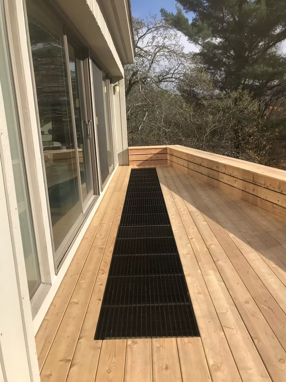 A wooden deck with a black rug on it.