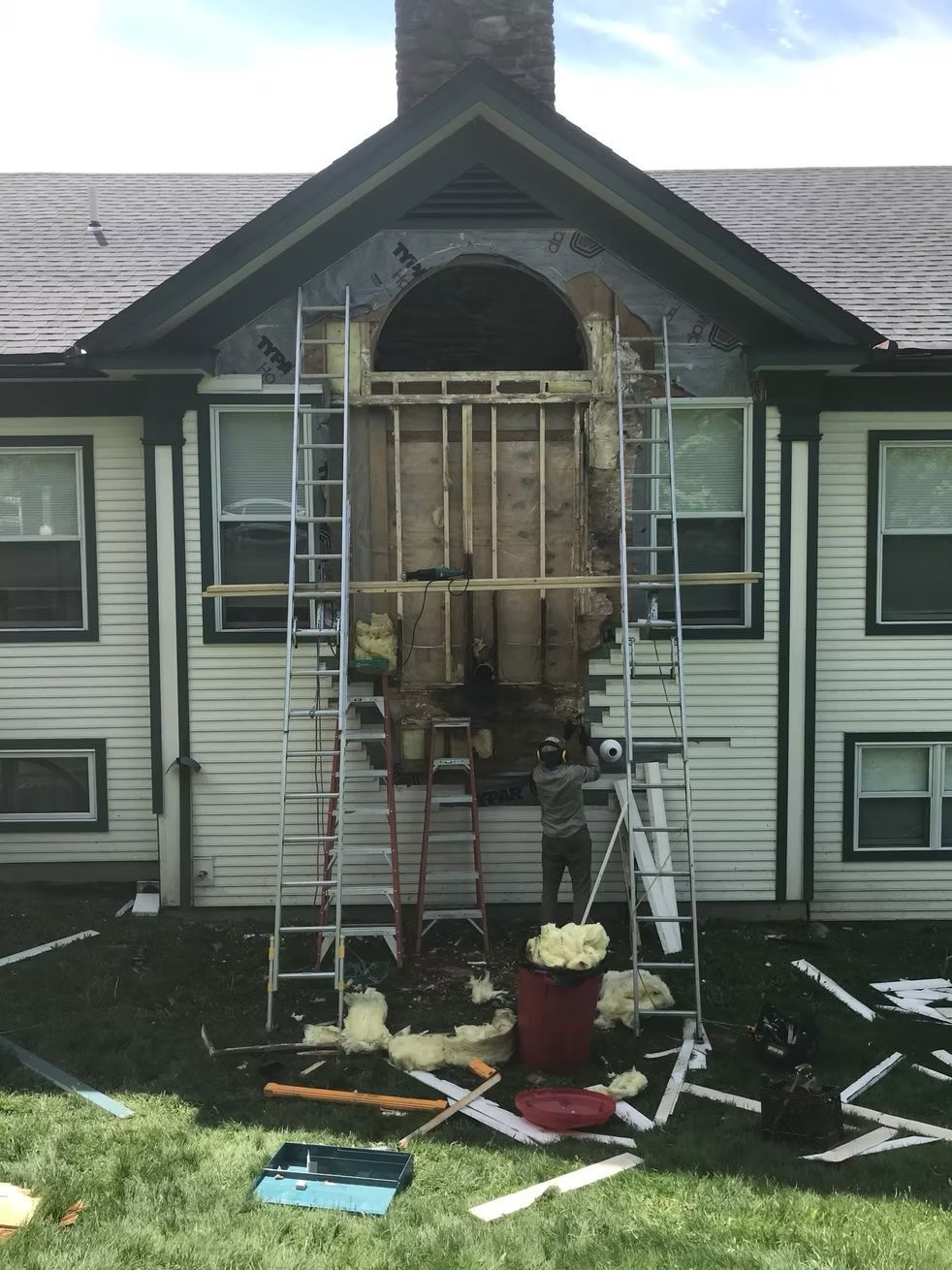 A house is being remodeled with a ladder in front of it.