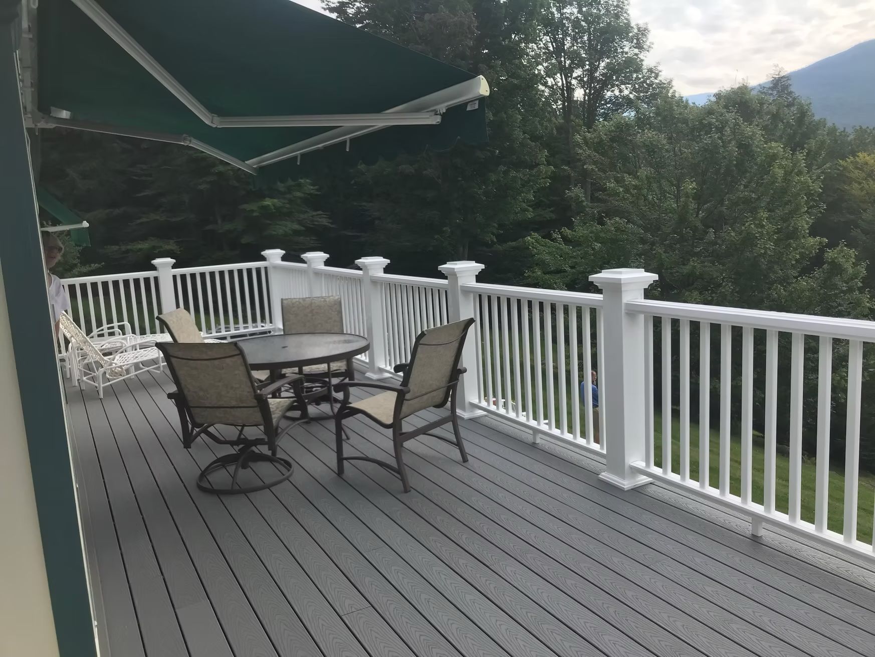 A deck with a table and chairs under an awning
