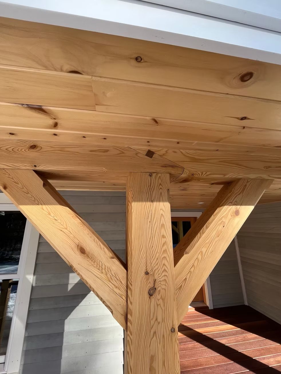 A close up of a wooden structure with a white house in the background.