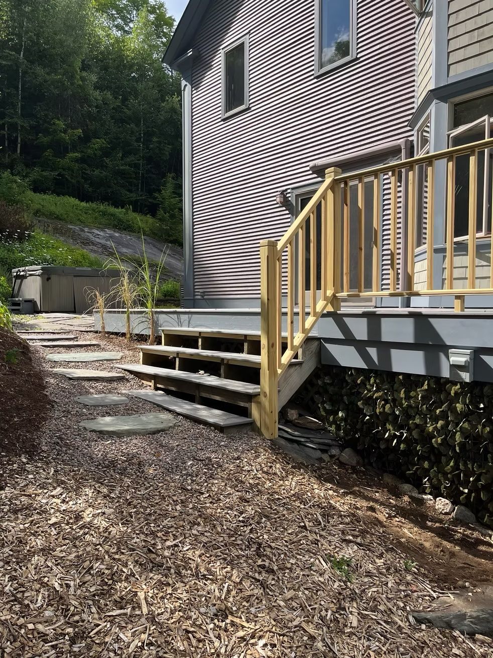 A house with a deck and stairs in front of it.