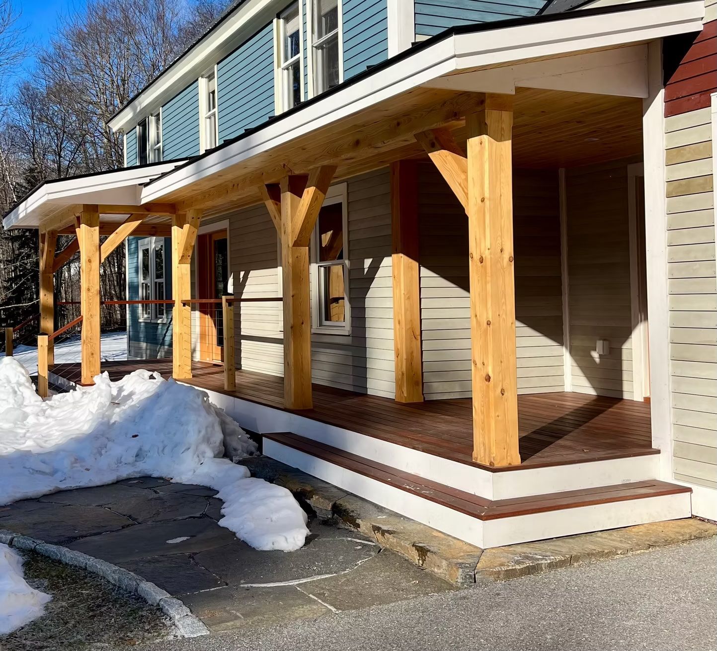 A house with a wooden porch and snow on the ground