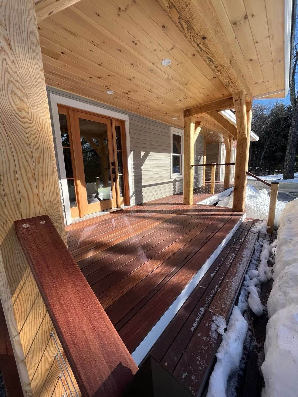 A wooden porch with stairs leading up to a house.