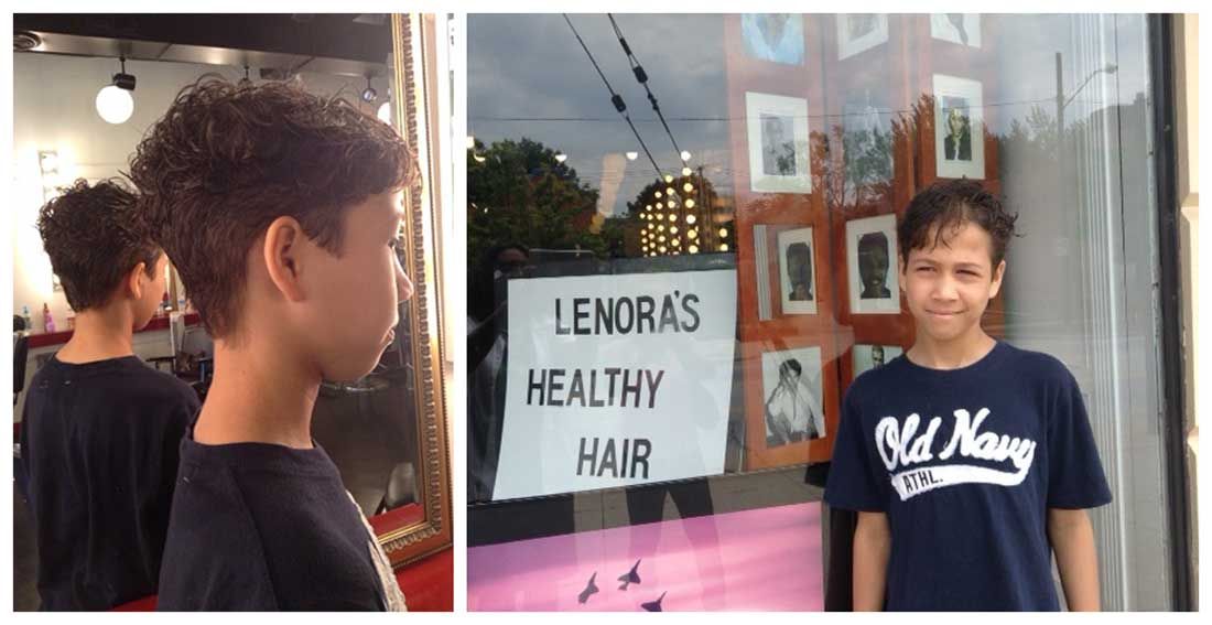 A boy is standing in front of a sign that says lenoras healthy hair