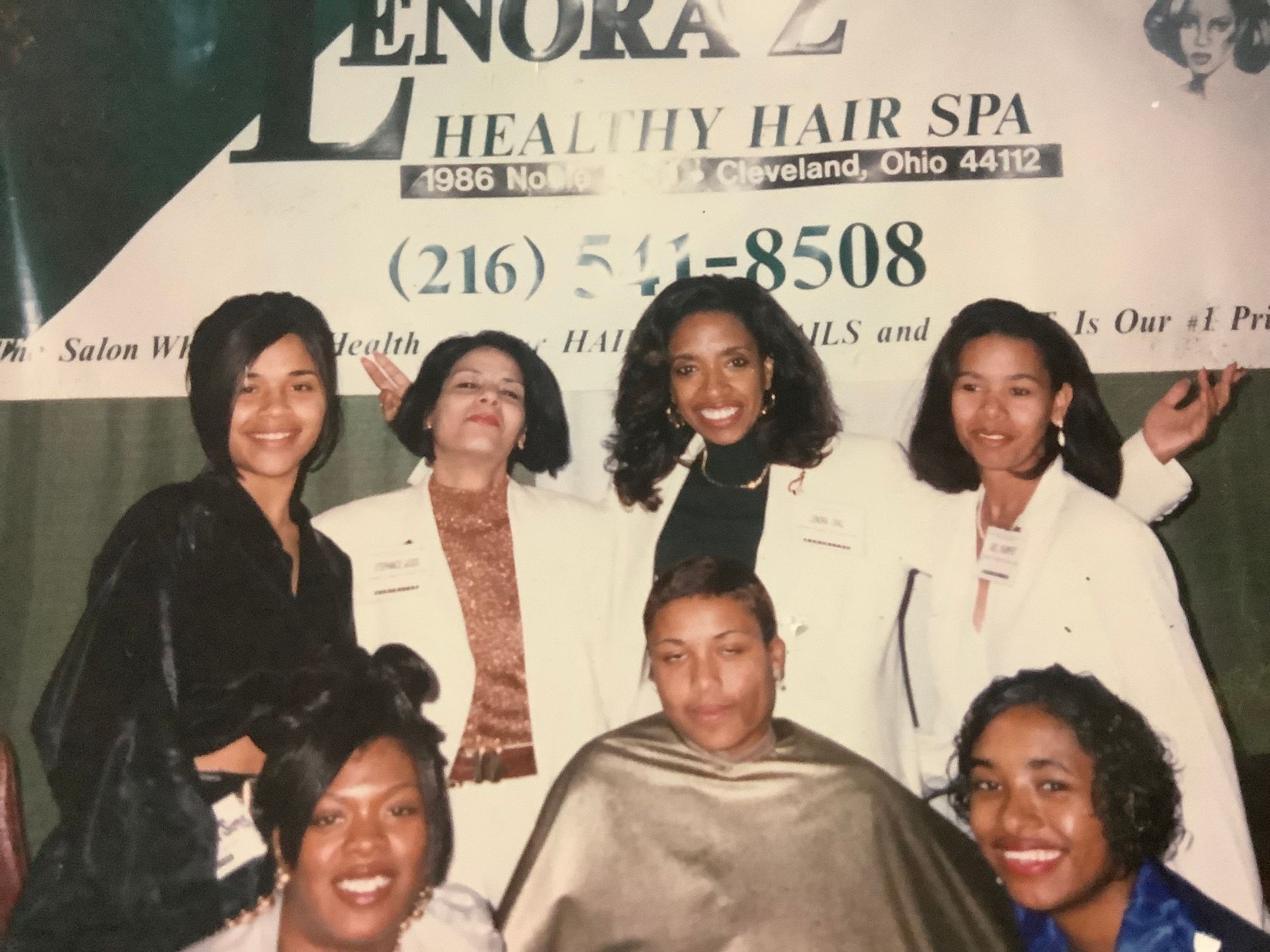 A group of women standing in front of a sign that says healthy hair spa