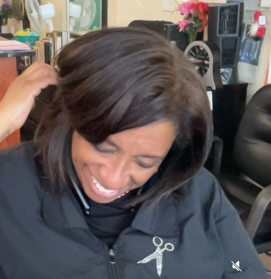 A woman wearing a black jacket with scissors on it