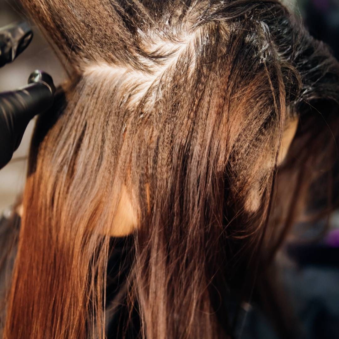 A woman is getting her hair blow dried in a salon