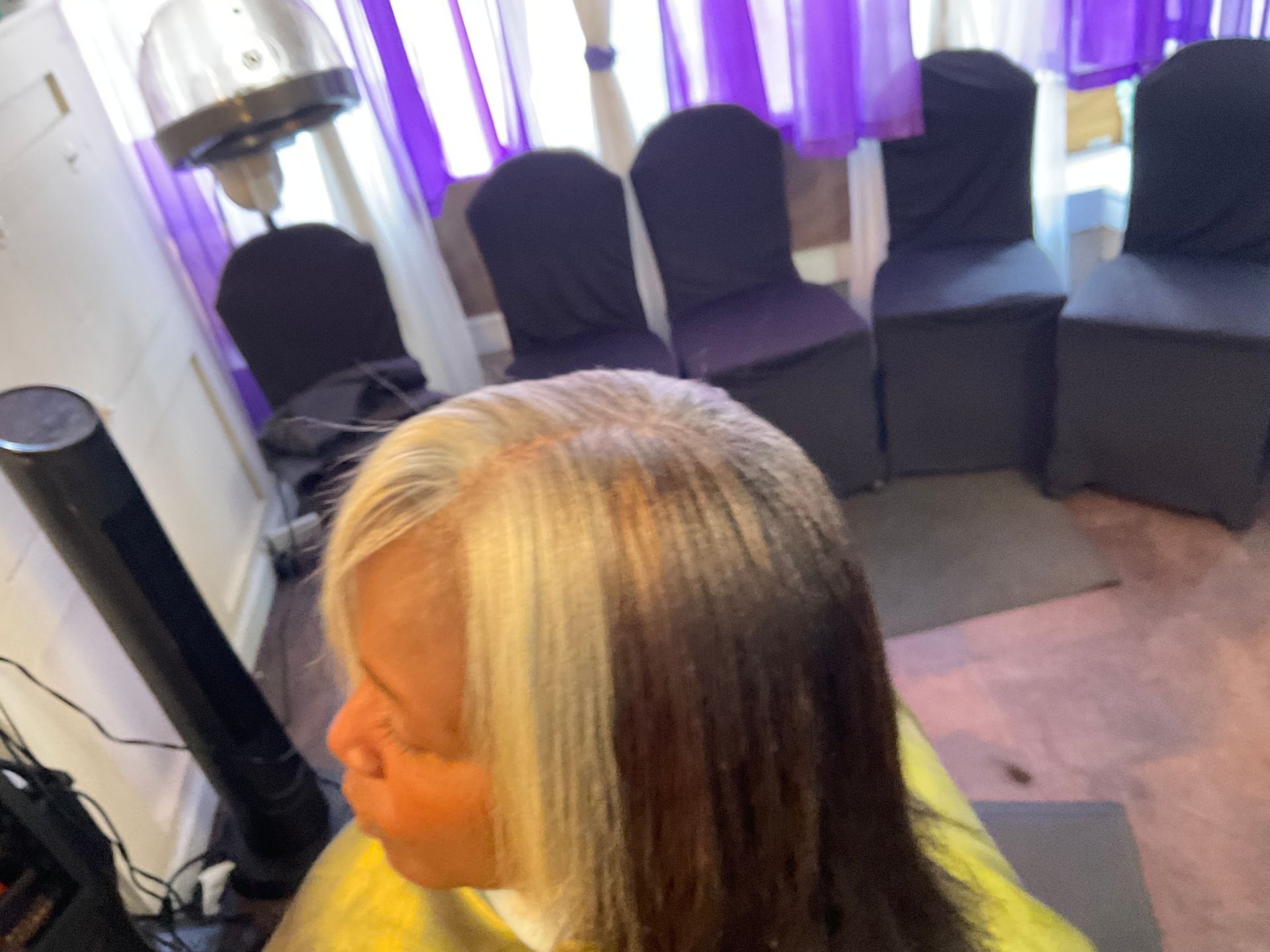 A woman is getting her hair cut in a salon