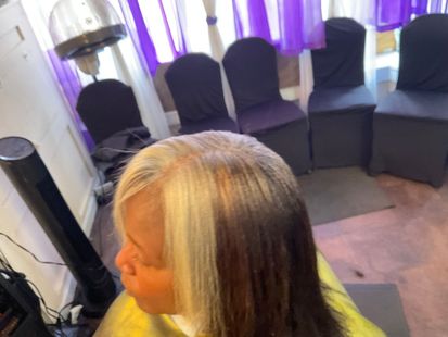 A woman is getting her hair cut in a salon