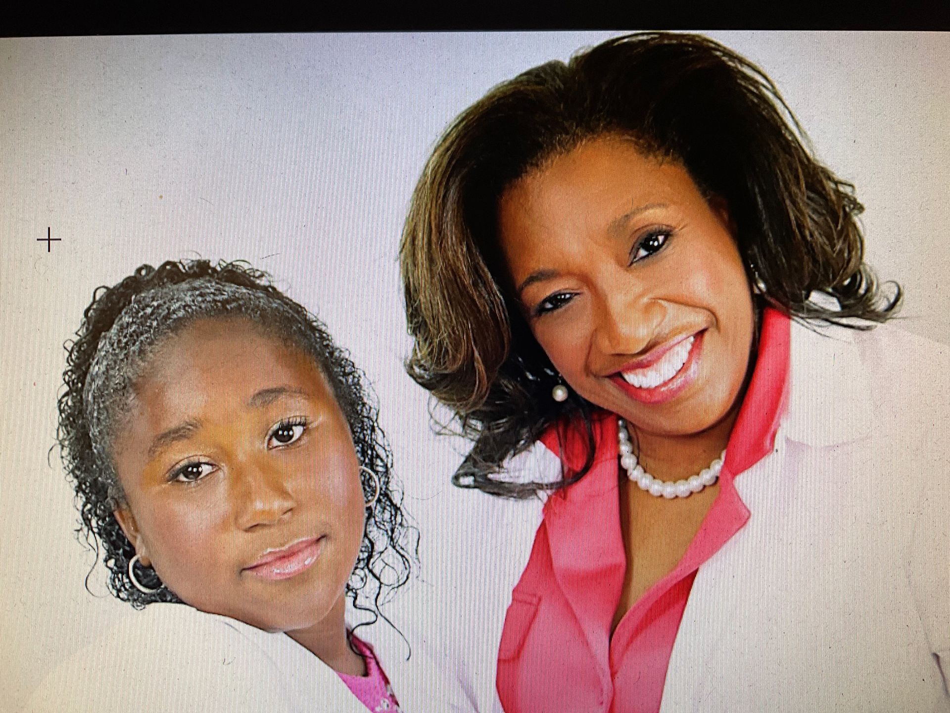 A woman and a girl are posing for a picture and smiling