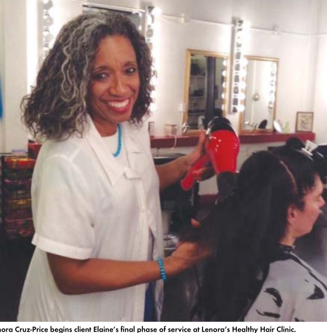A woman is blow drying another woman 's hair in a salon